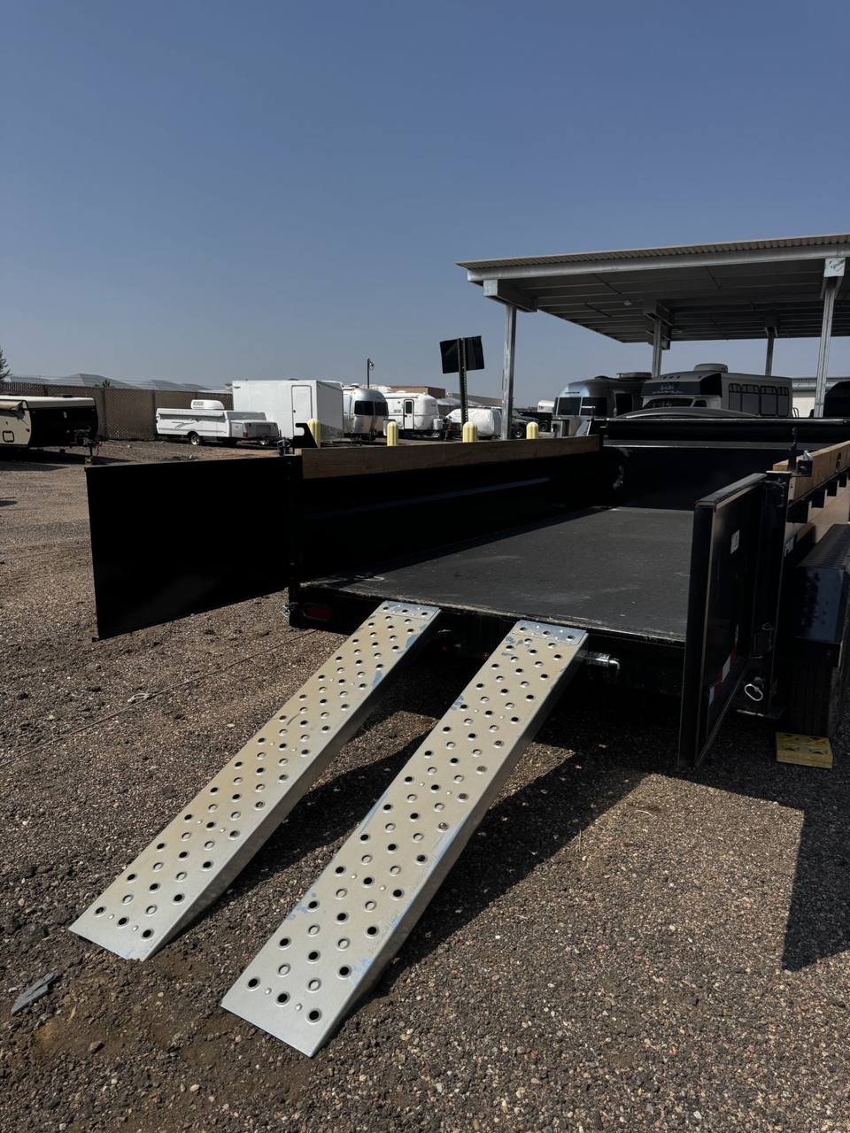 Double barn doors swung open with loading ramps deployed to the ground